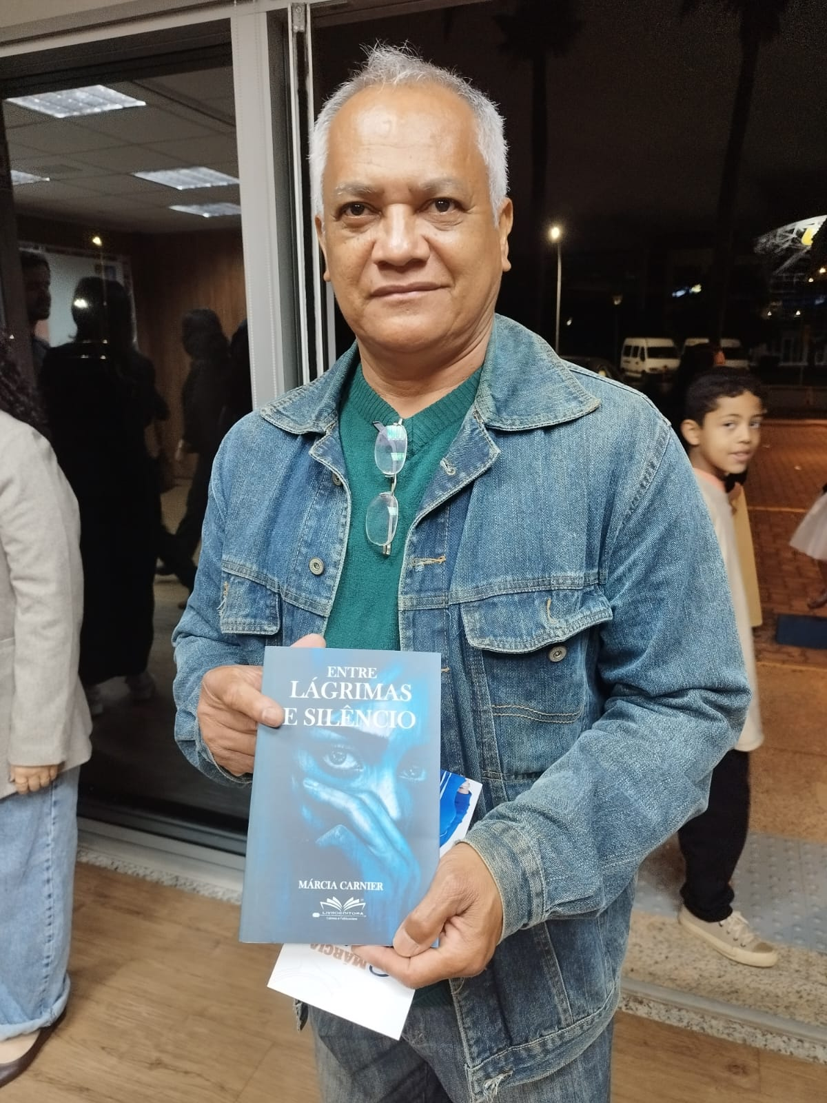 Leitor mostrando o livro Entre Lágrimas e Silêncio