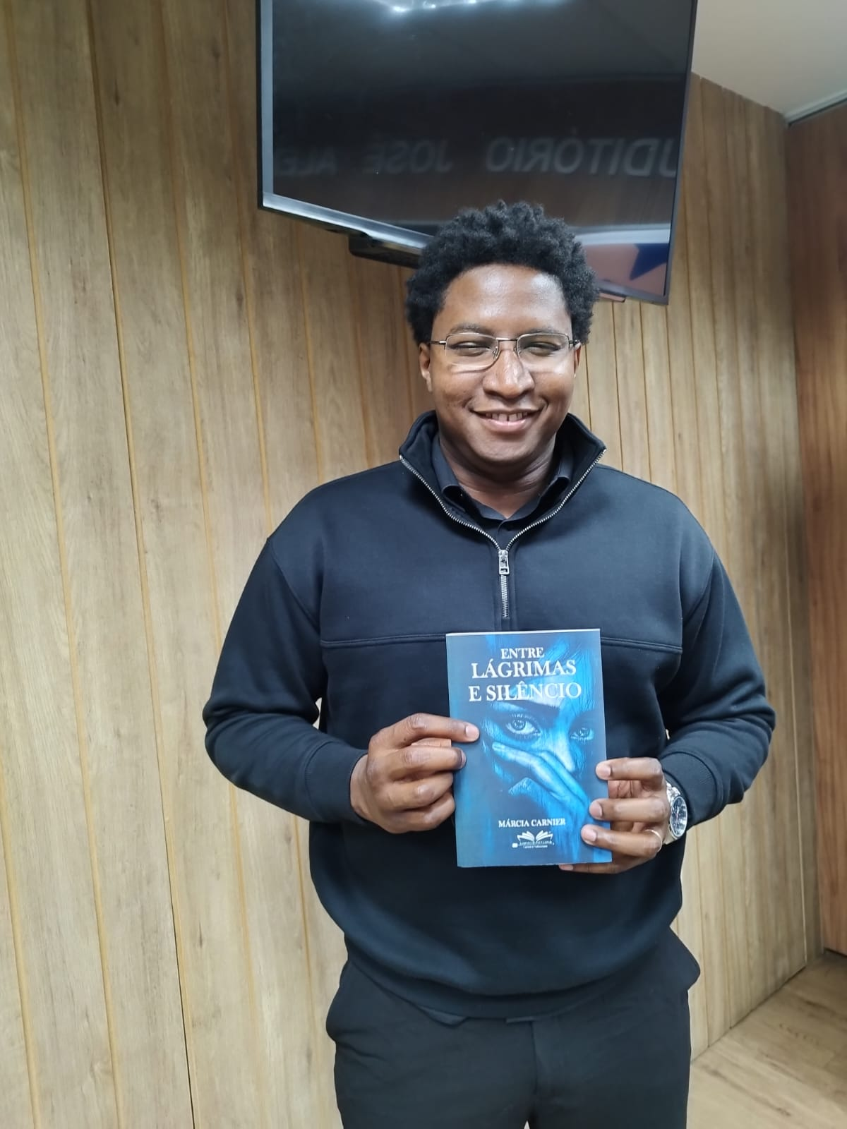 Leitor segurando o livro Entre Lágrimas e Silêncio